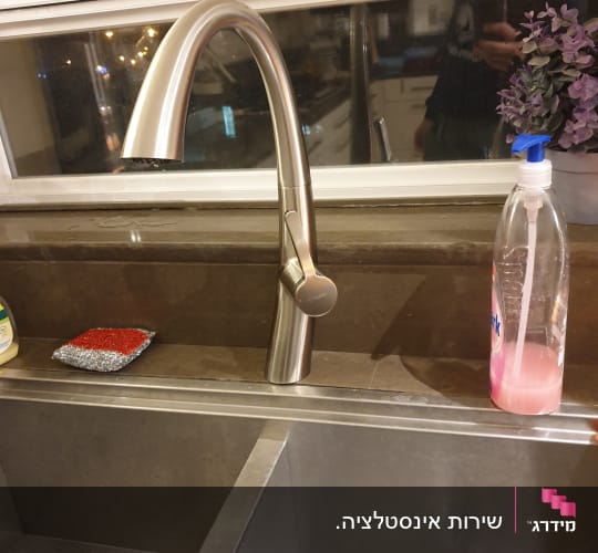 ברז נירוסטה מעל כיור מטבח עם סבון כלים